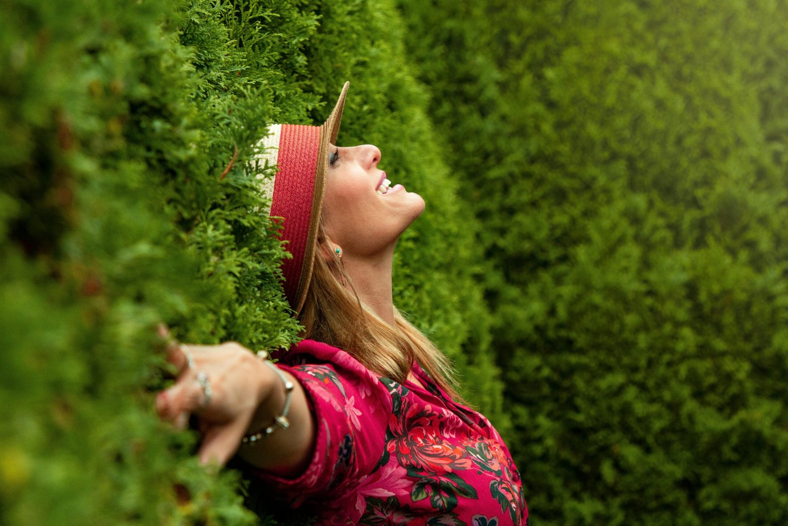 A joyful woman enjoying nature, embracing freedom in a lush green park.